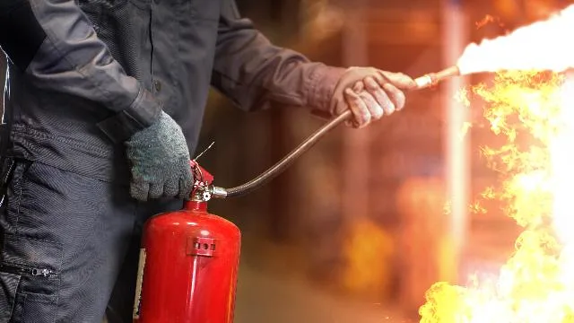 Person using a fire extinguisher on a training fire